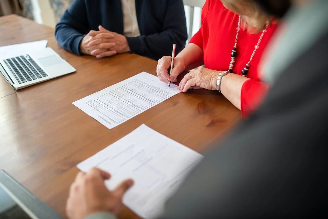 elderly couple signing lawyer contract